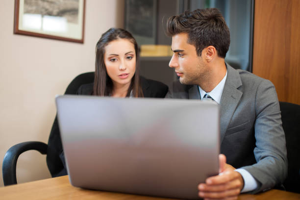 istock Smiling business people using a laptop computer in their office 639512096