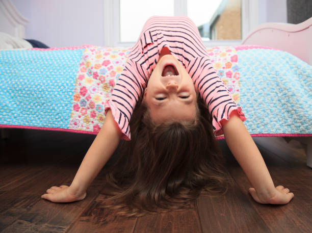 Playful little girl goofing around in her bedroom Playful little girl goofing around in her bedroom child 10 11 years 8 9 years cheerful stock pictures, royalty-free photos & images