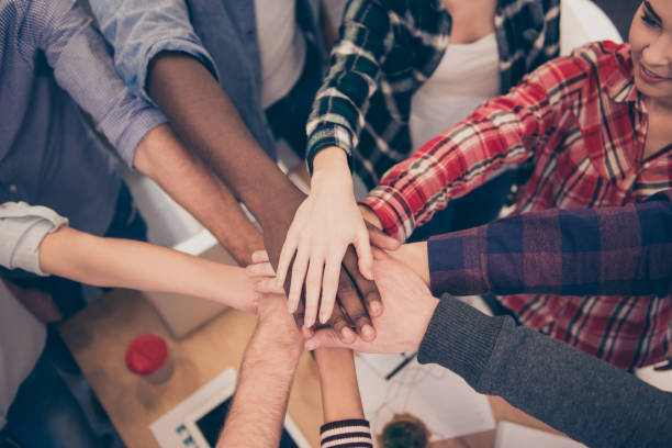 istock diverse multinational businesspeople putting hands on top of hands 639518108