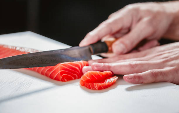 istock Close up on slicing raw salmon with sharp knife 639518524