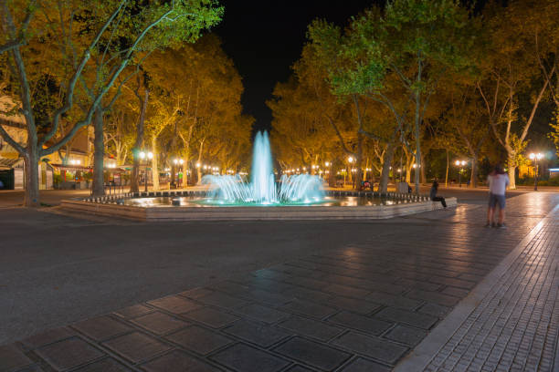 istock Illuminated fountain and tree lined promenade long exposure 639518624