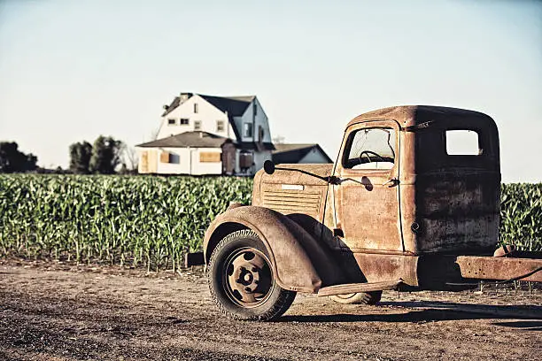 Photo of Abandoned Old Truck and Boarded Up Farmhouse