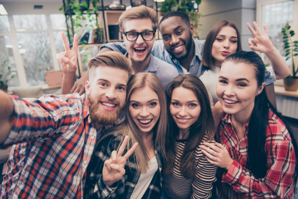 istock Young happy friends  gesturing v-sign while making selfie 639521544