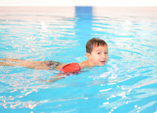 istock Little Boy Swimming in Pool with Arm Floats 639524672
