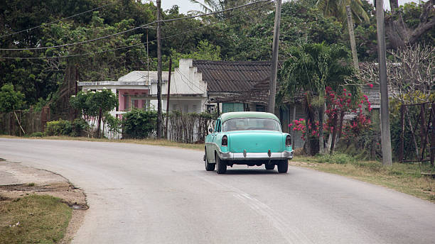istock Classic aquamarine old car driving on Cuban road. 639525134