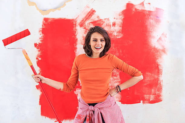 istock Smiling housewife holding paint roller on stick 639528766