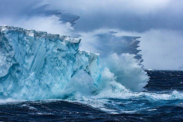 enorme iceberg che galleggia in antartide in una tempesta - uncultivated snow ice antarctica foto e immagini stock