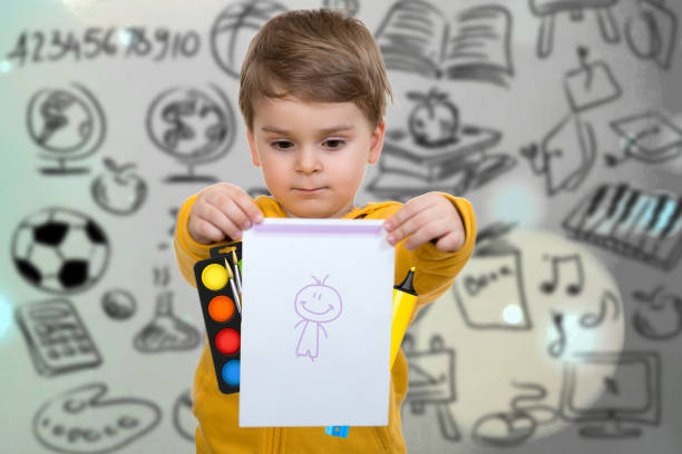 Little boy holding his first drawing in hands.