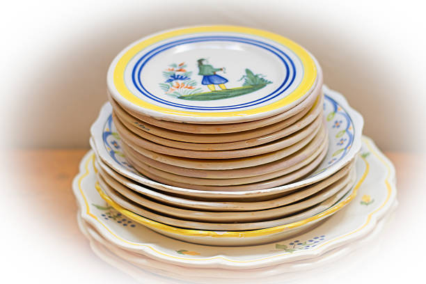 Stack of pretty vintage rustic French plates (close-up) in whites, blues, and yellows. Copy space available.