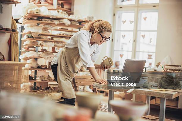 Potter Entrepreneur Using Laptop In Workshop Stock Photo - Download Image Now - Small Business, Owner, E-commerce