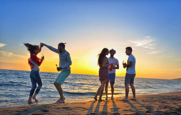 istock group of young people dancing at the beach 639534488