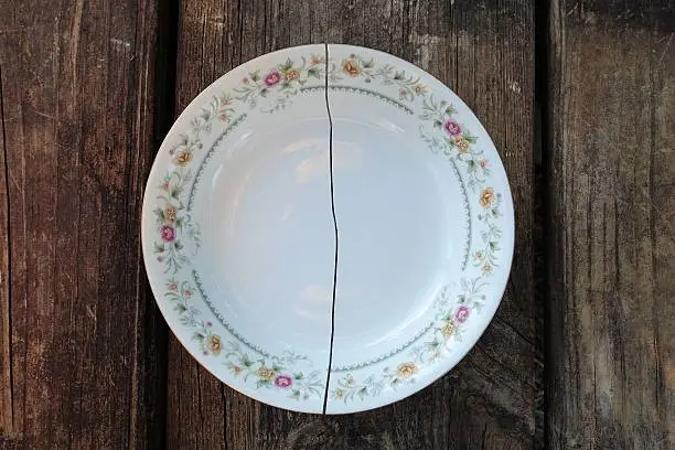 Photo of Broken plate cracked down the middle. Broken dreams