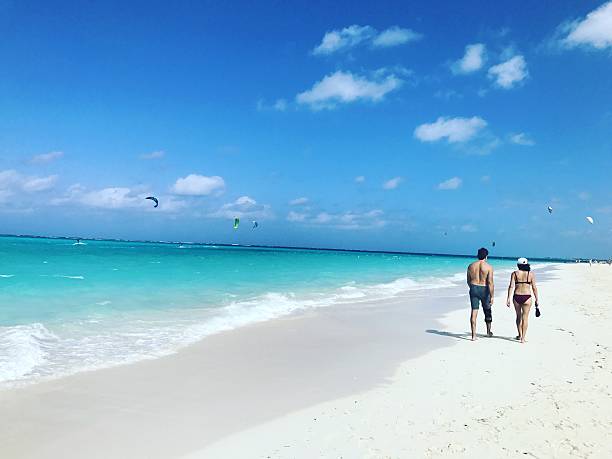 Couple walking on the beach. Turks and Caicos Islands Providenciales, Turks and Caicos Islands - January 24, 2017: Couple walking on Grace Bay Beach, Providenciales, Turks and Caicos Grace Bay stock pictures, royalty-free photos & images