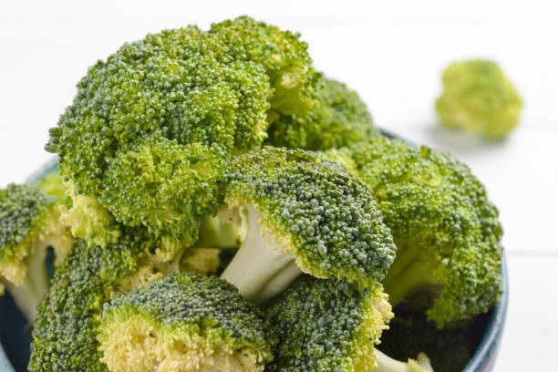 istock Bunch of fresh green broccoli on blue bowl 639543154