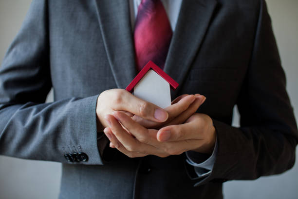 istock Business man in suit using hands covering and protecting house 639546016