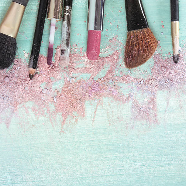 istock Makeup brushes and lipstick on teal blue background 639548564