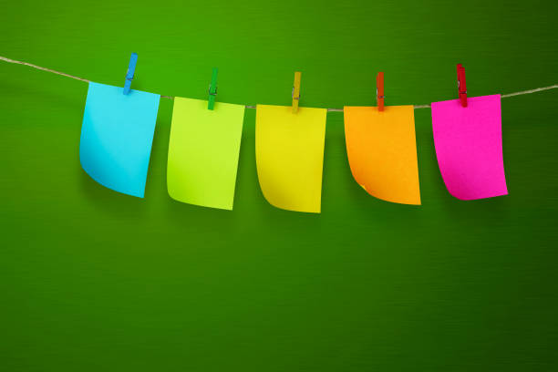 липкие заметки, висящие на прихотье с светло-зеленым фоном - clothesline clothespin adhesive note bulletin board стоковые фото и изображения