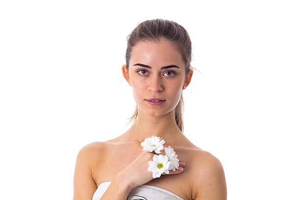 Roll up clean towel  on white table with blurred image of sexy woman in white bikini background, copy space for product display.