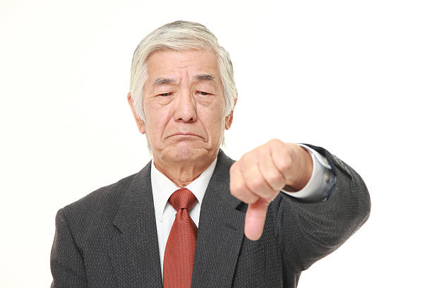 старший японский бизнесмен с пальцем вниз жеста - heckling стоковые фото и изображения