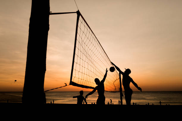 beach volleyball silhouette at sunset , motion blurred - volleying sport summer men imagens e fotografias de stock