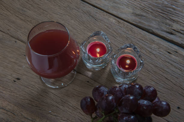red wine in glass for a romantic and  candle on wooden table.