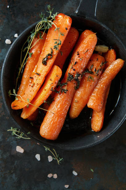 istock Baked carrots with heavy frying pan on rustic background 639558542