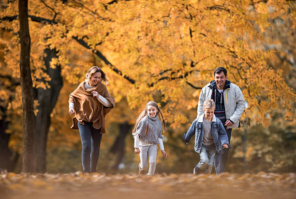 istock Happy family having fun while running in autumn day. 639562282