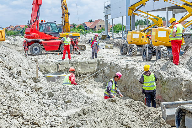 Assembly concrete drainage manhole on building site Zrenjanin, Vojvodina, Serbia - May 29, 2015: Building activities during construction of the large complex shopping mall "AVIV PARK" in Zrenjanin city.  trench stock pictures, royalty-free photos & images