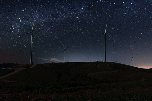 The milky way star on the sky with wind turbine in dark night