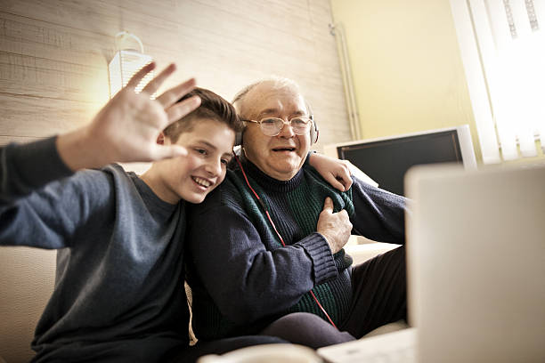 istock Grandfather using laptop with grandson 639567154