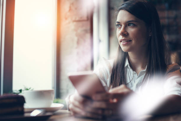 istock Woman using phone sitting alone in cafe and texting 639568368