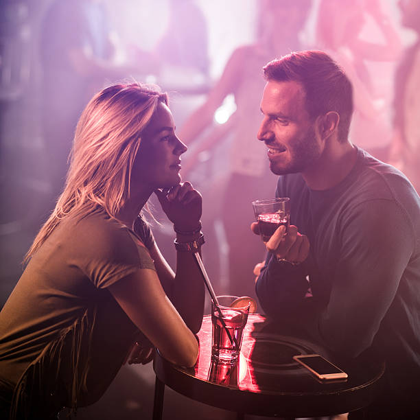 istock Young smiling couple talking during a date in nightclub. 639569320