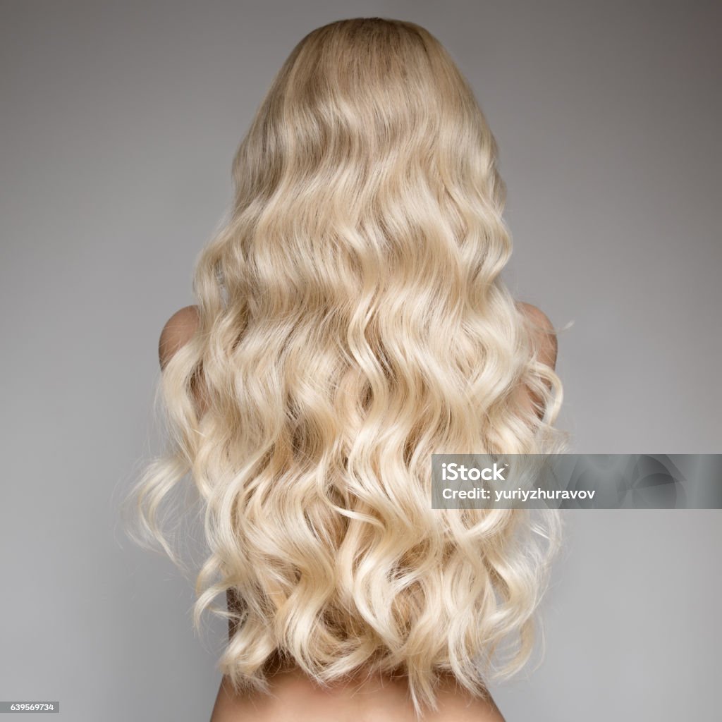 Schöne junge blonde Frau mit langen welligen Haaren. Rückansicht - Lizenzfrei Blondes Haar Stock-Foto