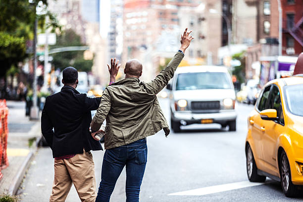 hommes couple en hélant pour vous un taxi à new york - people traveling business travel travel new york city photos et images de collection