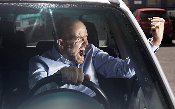 Motorist pulls a fist at bad driver while driving stock photo