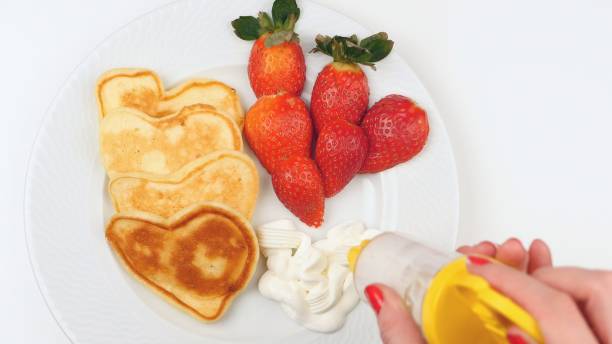 istock Heart-shaped pancakes with strawberry on a white dish. 639573064