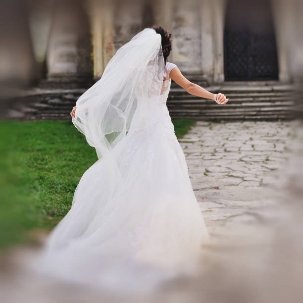 istock brunette bride walking next to old church 639573800