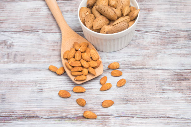 istock Almonds peeled kernels and nuts in shell on wooden background 639576540