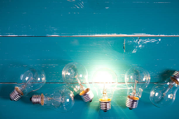 istock Vintage incandescent bulbs on turquoise wooden table 639577142