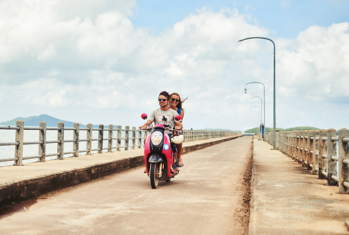 Shot of a young couple enjoying a scooter ride