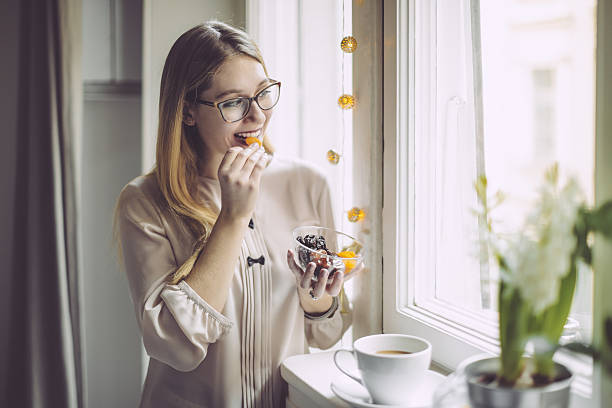 Young woman at home Young woman at home dried fruit stock pictures, royalty-free photos & images
