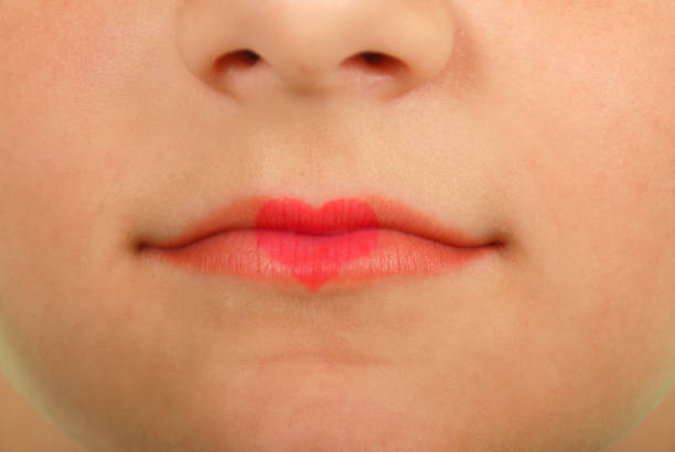 istock Young beautiful girl playing with heart drawing on lips 639581628