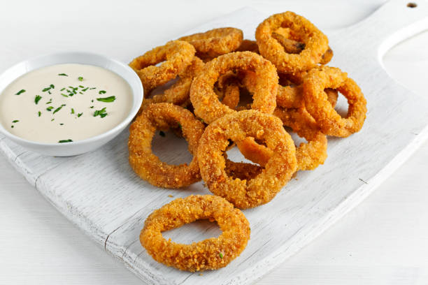 istock Fried Breaded Onion Rings with sauce. on white wooden board 639583938