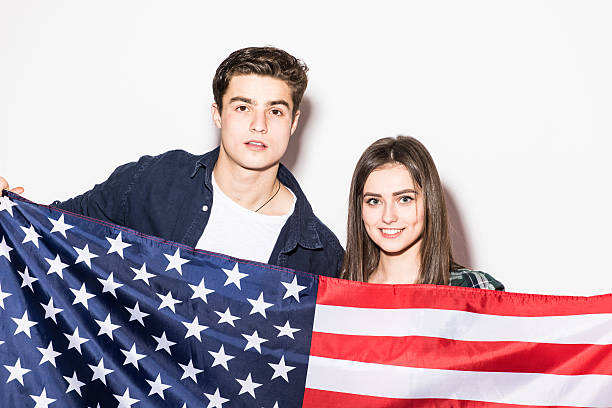 istock Young couple with US flag in hands on white background 639588156