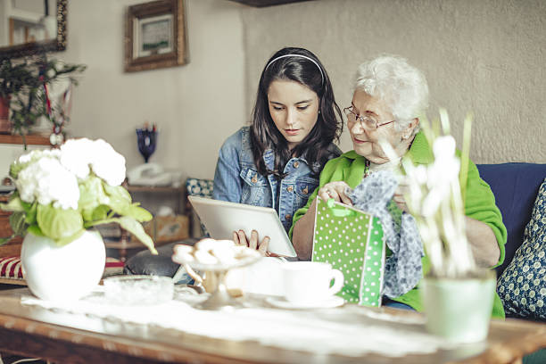 assistente social está visitando uma mulher idosa - wireless technology cheerful granddaughter grandmother - fotografias e filmes do acervo