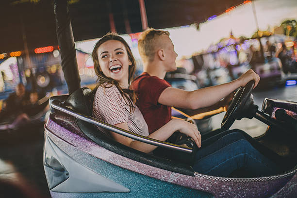 Couple in Bumper Cars Boyfriend and girlfriend in bumper car looking to cause some damage to others around them! teen romance stock pictures, royalty-free photos & images