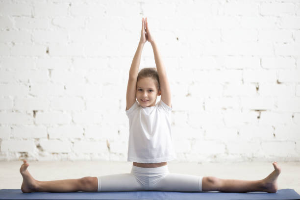 mädchen kind in samakonasana pose, weiße studio hintergrund - the splits flexibility yoga teenage girls stock-fotos und bilder