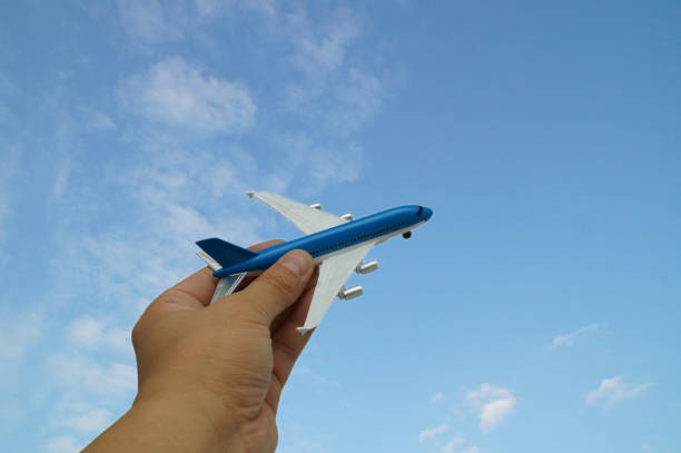 istock hand holding an airplane toward the sky 639591248