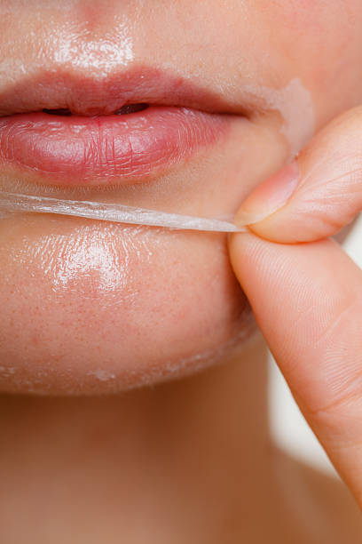 woman removing facial peel off mask closeup - peel off imagens e fotografias de stock