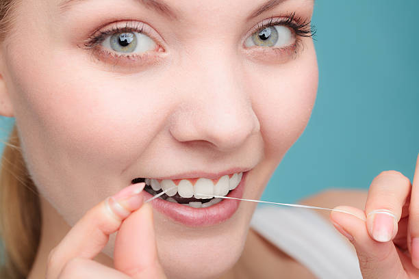 istock Woman face smiling with dental floss. 639601808